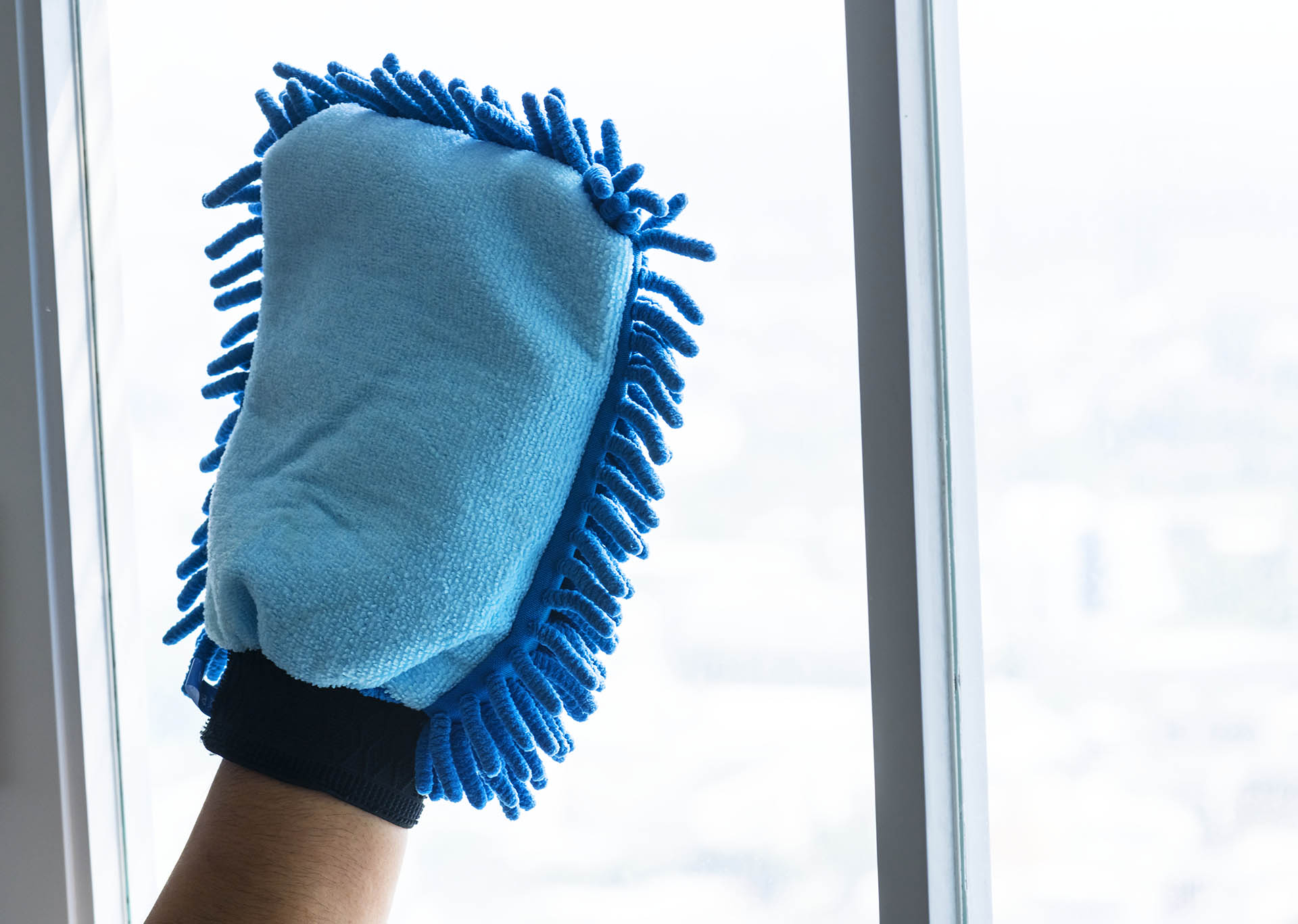 Closeup of hands cleaning window domestic chores concept